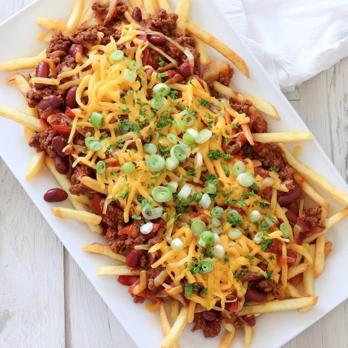 Melty cheddar blankets hearty chili and crispy fries, finished with green onions and optional sour cream.