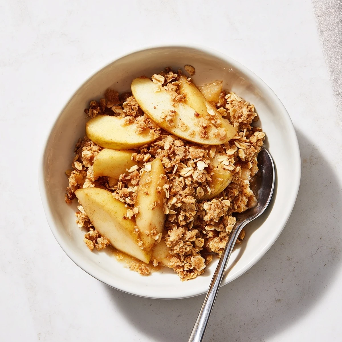 Golden brown Apple Crumble fresh from the oven, served warm in a baking dish with a scoop of vanilla ice cream melting on top.
