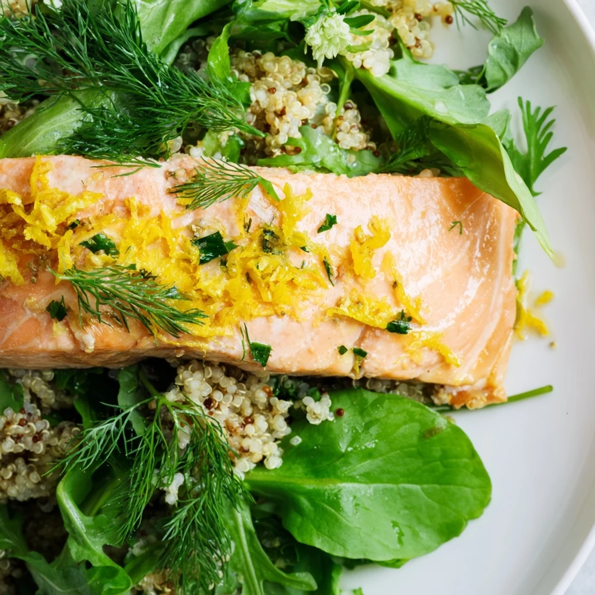 Serving suggestion for Lemon Herb Salmon Salad, plated with cucumber, red onion, and warm salmon fillet.