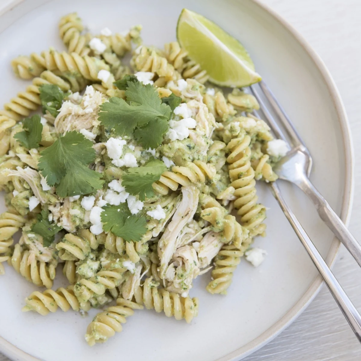 Heaping plate of creamy Cilantro Lime Chicken Pasta, topped with extra cilantro and a sprinkle of spices.