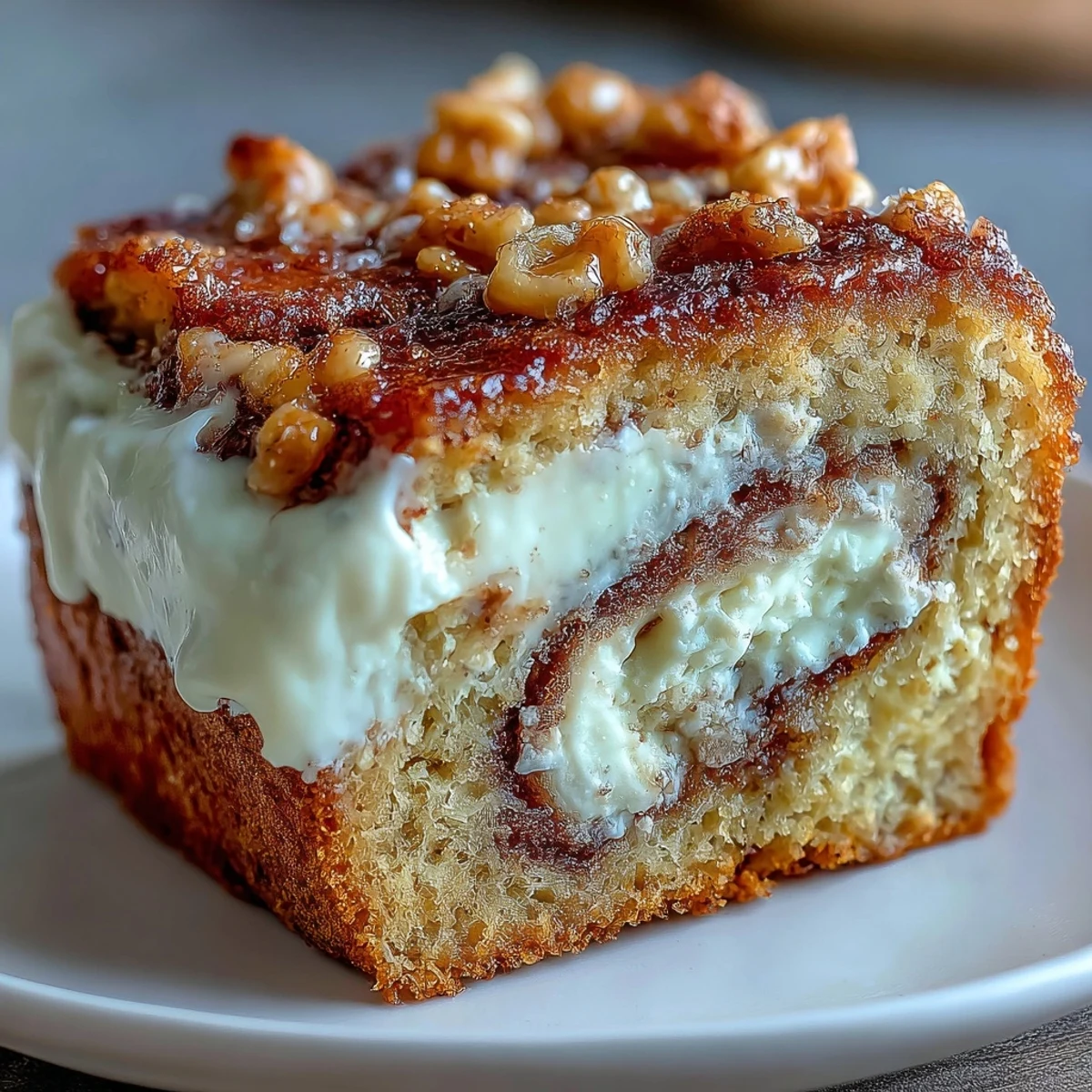 Freshly baked Cream Cheese Cinnamon Swirl Banana Bread slices rest on a rustic wooden cutting board, displaying moist yellow crumb and visible creamy layers.