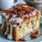 A freshly baked Heavenly Blood Orange Yogurt Cake with a glossy orange glaze dripping down the sides, served for dessert.