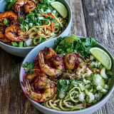 Vibrant bowl of 15-Minute Asian Noodle Bowl With Grilled Shrimp, with julienned carrots, cucumbers, and bell peppers alongside succulent shrimp on glistening noodles.  