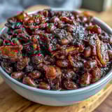 Close-up of tender navy beans coated in molasses-brown sugar glaze, topped with crunchy bacon crumbles.  