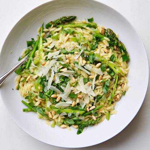 Shaved asparagus ribbons and tender orzo pasta mingle with Parmesan and pine nuts in this fresh Asparagus Lemon Orzo Salad, drenched in zesty lemon dressing.