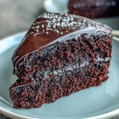 Perfectly layered Easy Chocolate Fudge Cake with silky-smooth ganache, ideal for a festive celebration centerpiece on the table.