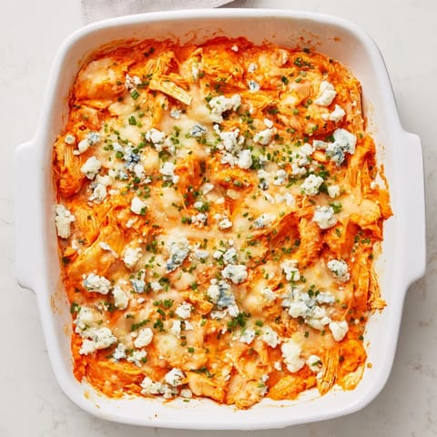 A creamy and spicy Buffalo Chicken Dip served with crunchy celery sticks and tortilla chips.