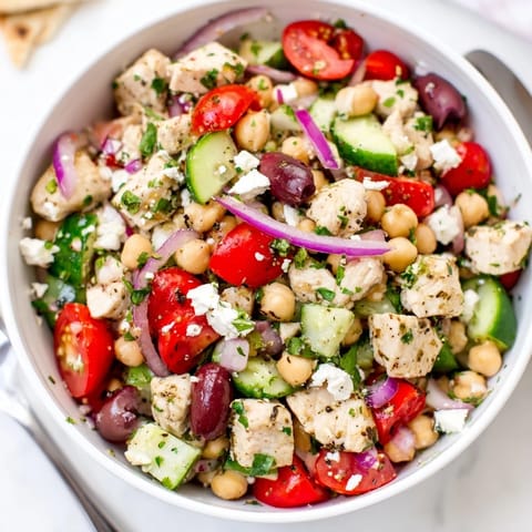 A close-up view of Mediterranean Chickpea Chicken Salad with crumbled feta, Kalamata olives, and a zesty lemon-oregano dressing.