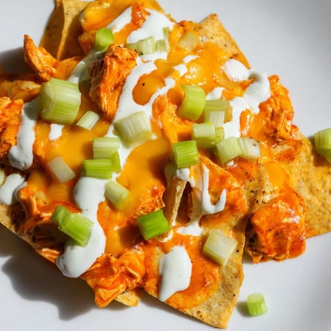 Warm tortilla chips layered with spicy buffalo chicken and melted cheddar cheese.  