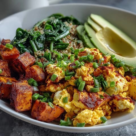 Savory Tofu Scramble Vegan Breakfast Bowl featuring fluffy quinoa, sautéed spinach, and seasoned tofu crumbles served warm for a satisfying meal.  