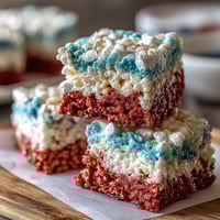 Patriotic Rice Krispies treats with red, white, and blue layers, perfect for Fourth of July celebrations and summer picnics.