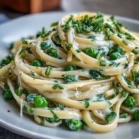 Spring pasta with lemon cream sauce and peas, a vibrant vegetarian dish bursting with fresh flavors and tender green peas.